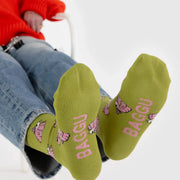 A person wearing a pair of BAGGU Crew Socks in Snoopy