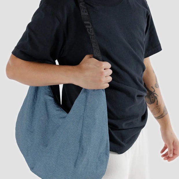 Person holding a A large Crescent Bag from Baggu in Digital Denim
