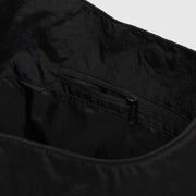 Interior pocket of a large nylon sling bag from Baggu in black