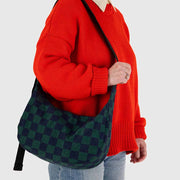 A close up of a person holding a medium Crescent Bag from BAGGU in Navy Green Check