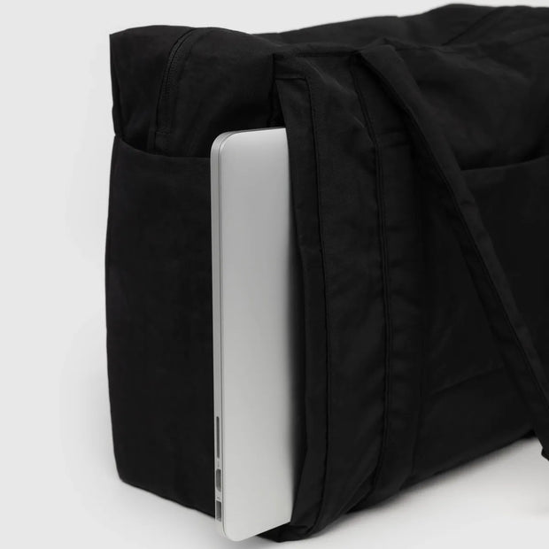 The tech pocket of a small Cloud carry-on from BAGGU in Black