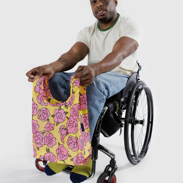 A Rose design Baby Baggu held by a person in a wheelchair
