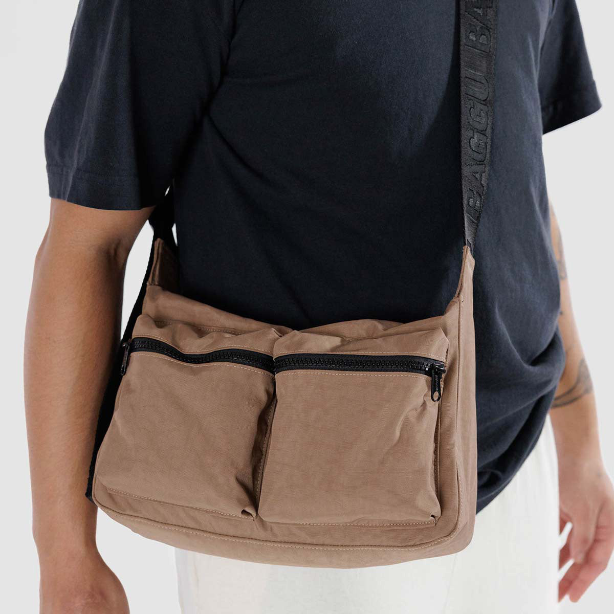 A person holding Baggu Medium Crossbody Cargo bag in Cocoa