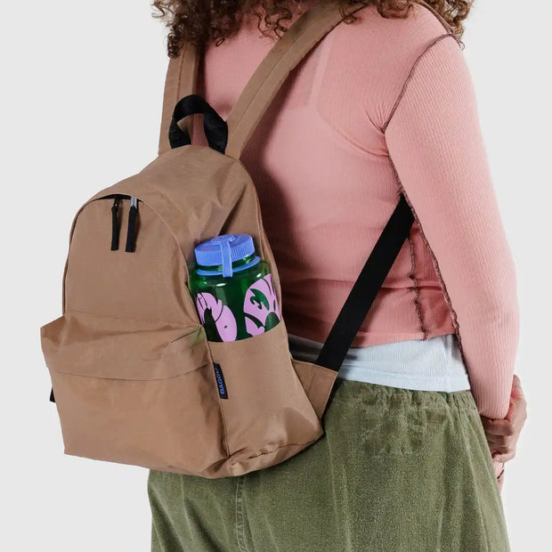 A person wearing a Baggu Medium Backpack in Cocoa