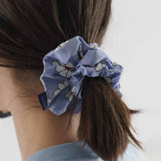 A person with the blue daisies design hair scrunchie