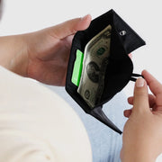 A person holding a Black Baggu Snap Wallet open 