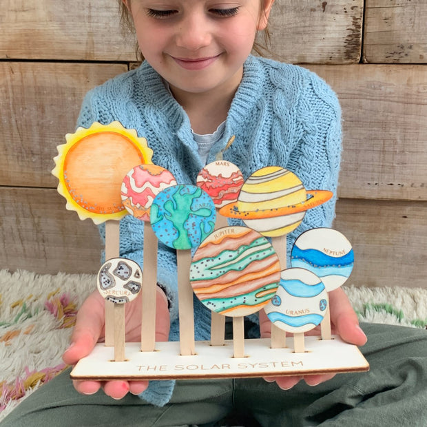 A child holding a  Solar System Craft Kit from Cotton Twist 