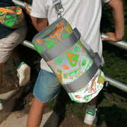 A boy wearing a LOQI kids dinosaur reflective mini weekender on their back