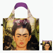 A recycled reusable bag from LOQI featuring the Self Portrait with Hummingbird artwork from Frida Kahlo photographed with its pouch.