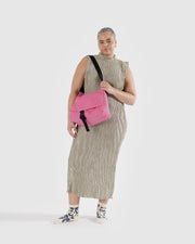 a Baggu Recycled Nylon Messenger Bag in Azalea Pink worncrossbody