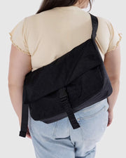 A Baggu Recycled Nylon Messenger Bag in Black worn crossbody