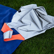 A lifestyle image of a neon orange reflective LOQI shopping tote bag shown at dusk